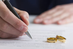 divorce-3-300x200 Hands of wife, husband signing decree of divorce, dissolution, canceling marriage, legal separation documents, filing divorce papers or premarital agreement prepared by lawyer. Wedding ring